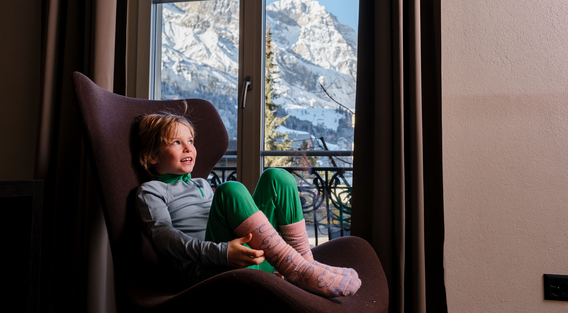 Kind in namuk Merino Thermounterwäsche schaut aus dem Fenster