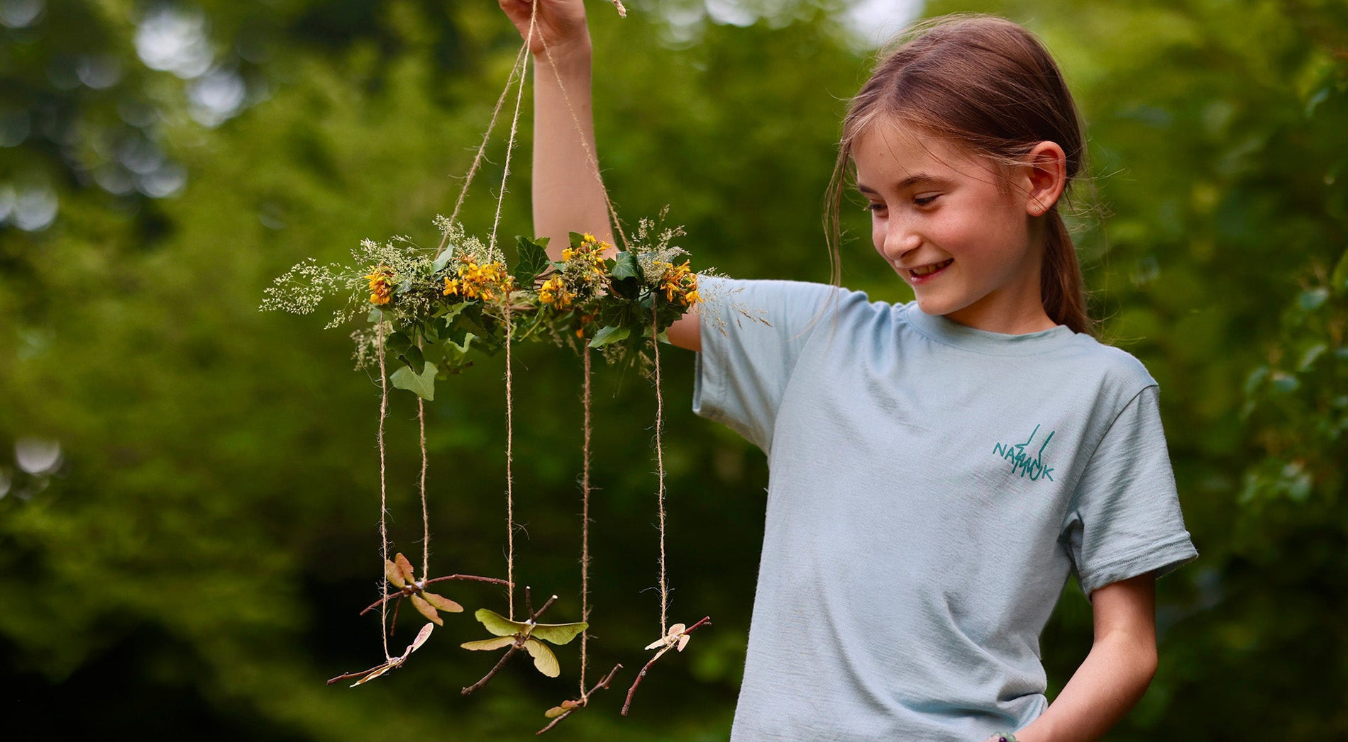 Mädchen mit Libellen-Mobile aus Naturmaterialien
