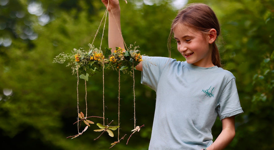 Mädchen mit Libellen-Mobile aus Naturmaterialien