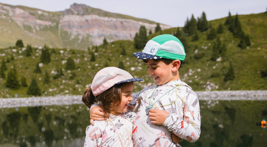 Zwei Kinder stehen vor einem Bergsee